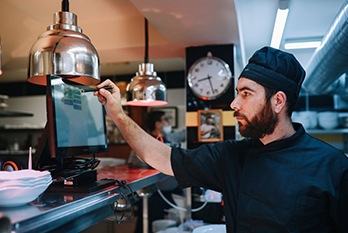 Kitchen employee checking the order from the screen